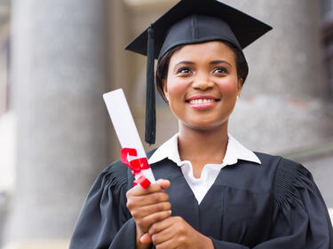 Woman in cap and gown holding a diploma